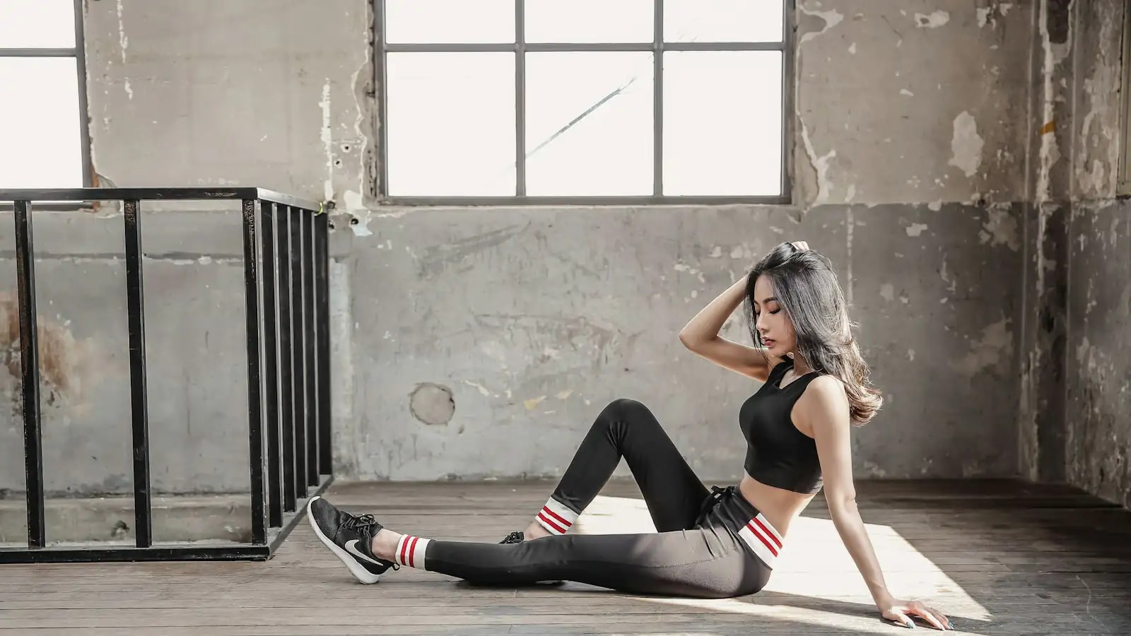 Mulher com roupa de treino sentada em um estúdio